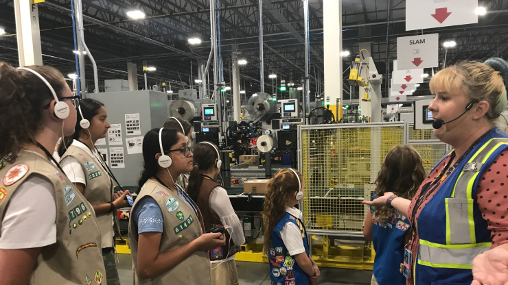 Regan Quilty leads a tour of Girl Scouts at the New Jersey Amazon Fulfillment Center.  The girls learned how people handle robots in the warehouse.